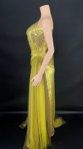 Detailed side view of a gold sequined one-shoulder evening dress with sheer mesh skirt overlay