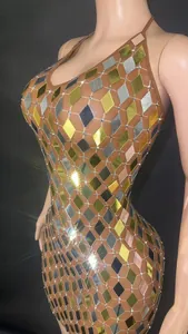 Detalle macro de un minivestido brillante con lentejuelas de espejo doradas y plateadas