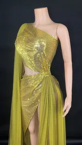 Detailed macro view of luxury gold sequin one-shoulder evening dress with tulle drape