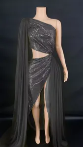 Detailed view of a black one-shoulder sequin evening dress with a high side slit.