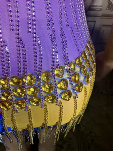 Close-up of sparkling rhinestones and golden heart gems on colorful fringe party dress