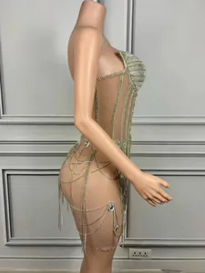 Dettaglio di mini abito da festa trasparente con frange di strass argentati