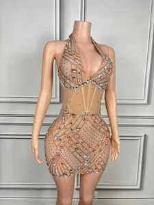 Detail van een nude mesh mini-jurk met strass-steentjes en halternek op etalagepop.