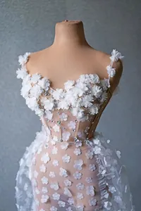 Vue détaillée d'une robe de soirée blanche avec fleurs 3D et ornements en strass