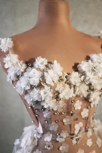 Gros plan détaillé d'une robe de soirée élégante en tulle blanc avec fleurs et cristaux