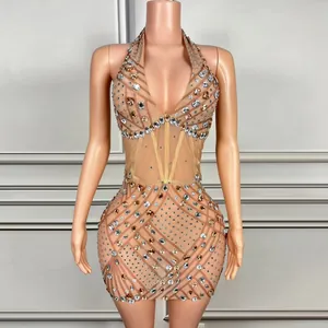 Detailweergave van een huidkleurige halterjurk van mesh met dichte strassteentjes.