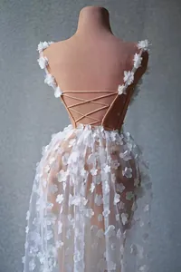 Détail d'une robe de soirée élégante en tulle blanc avec fleurs 3D et dos nu lacé
