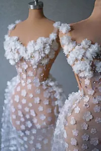 Détail d'une élégante robe de soirée blanche avec appliques florales 3D et strass