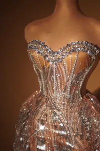 Dettaglio dell'abito da sera di lusso in paillettes oro rosa e scollo con strass