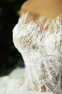 Dettaglio ravvicinato dei ricami di paillettes bianche su un elegante abito da sera