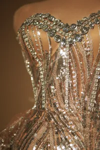 Dettaglio di paillettes argento e strass sul corpino di un abito da sera di lusso