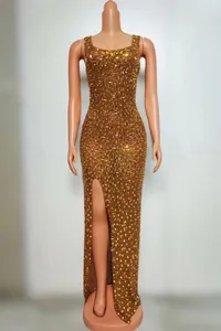 Full view of elegant gold rhinestone embellished slim fit long evening gown with slit