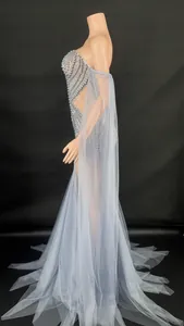 Détail d'une robe de soirée bustier perlée avec jupe longue en tulle et traîne élégante.