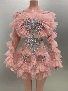 Detailed view of pink mesh ruffled long-sleeve dress with rhinestone embellishments