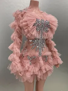 Detail view of a pink ruffled mesh mini dress featuring sparkling rhinestone embellishments.