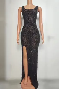 Front view of an elegant black evening dress with rhinestones and a daring high leg slit.