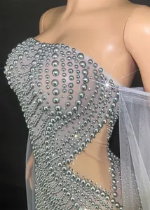 Gros plan d'une élégante robe de soirée bustier avec broderies de perles argentées sur tulle.