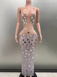 Macro view of the silver star sequins and white pearl details on this sheer evening gown.