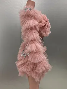 Exquisite side view detail of a pink ruffled mesh mini dress with elegant rhinestones.