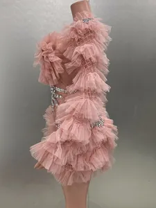 Detailed side view of pink ruffled mesh mini dress with sparkling rhinestones