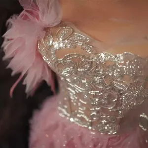 Dettaglio di abito francese rosa con intricati ricami di paillettes argentate.
