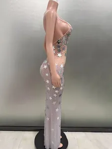 Side view of a sleeveless sequin party dress with stars on a nude mesh base