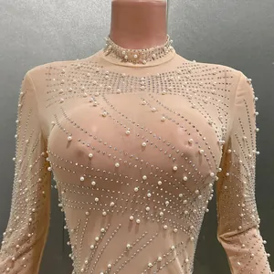 Detailansicht der eleganten Perlen- und Strassmuster auf einem beigen Bodysuit