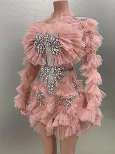 Detailed shot of a pink ruffled mesh mini dress with sparkling rhinestone embellishments