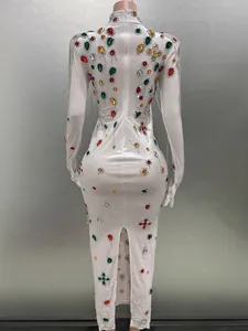Close-up back view of a white bodycon gown with colorful rhinestones and fringes.
