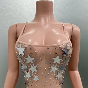 Close-up of nude mesh evening dress with silver stars and pearls