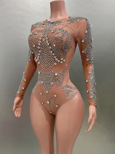 Détail complexe de strass argentés sur un body transparent en maille à manches longues