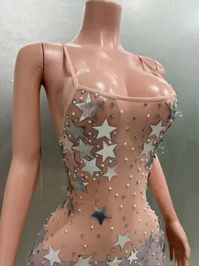 Close-up of nude mesh party dress with silver stars and pearl embellishments
