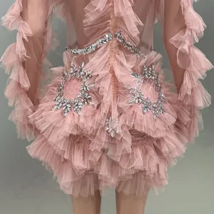 Close-up detail of pink mesh ruffles and silver rhinestone accents on a stylish mini dress