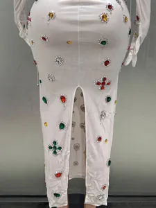 Detail view of white bodycon dress with vibrant rhinestone embellishments and back split