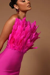 Detail showing the lush fuchsia feather trim on a strapless bodycon bandage midi dress.