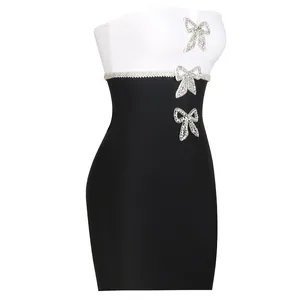 Detail of a black and white bandage dress with sparkling rhinestone bow decorations.