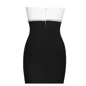 Detailed view of back zipper on a black and white strapless bandage dress with rhinestones