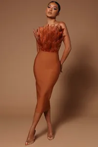 Detail showing the elegant feather-adorned bodice of a brown midi bandage dress