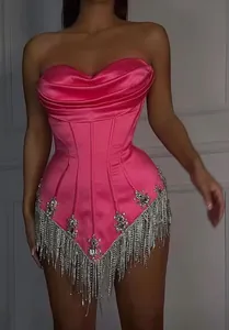 Detailed front view of a hot pink corset mini dress featuring luxury rhinestone fringe