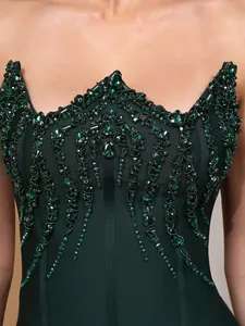 Detail view of emerald green sequins on dark green strapless bandage evening gown.