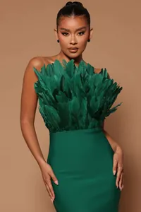 Close-up detail of emerald green strapless midi dress with lush feather bust decoration
