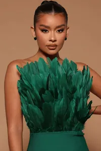 Detail view of emerald green strapless bandage dress with lush feather texture