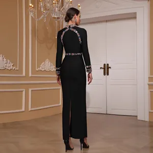 Elegant black long-sleeve evening gown with colorful beadwork and high slit back view.