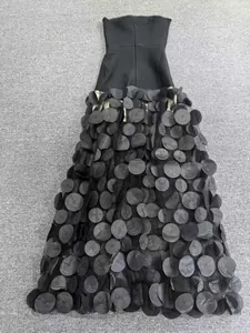 Détail d'une robe bandage noire sans bretelles avec jupe ornée de pétales de tissu