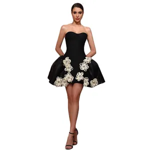Elegant black strapless bandage mini dress with floral appliqués and puff skirt.