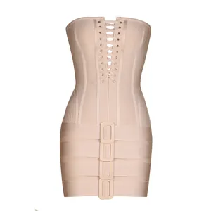 Macro detail of the lace-up corset front and fabric-covered buckles on the apricot bandage dress