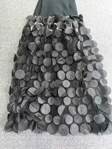 Gros plan d'une robe de soirée noire avec appliqués de pétales 3D sur tulle