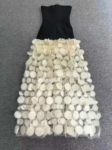 Détail de la robe bustier bandage noire avec jupe en tulle à pétales 3D blancs chic.