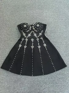Close-up of black bandage dress with intricate rhinestone flower beadwork detail