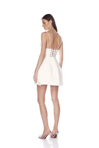 Vue arrière d'une mini robe blanche à bretelles avec fleurs 3D et dos lacé élégant.